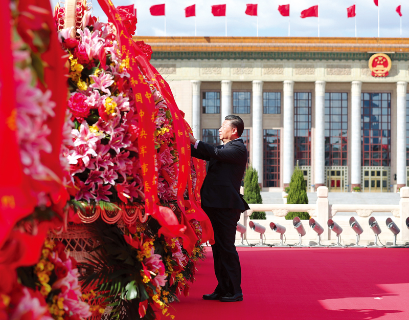 2018年9月30日上午，党和国家领导人习近平、李克强、栗战书、汪洋、王沪宁、赵乐际、韩正、王岐山等来到北京天安门广场，出席烈士纪念日向人民英雄敬献花篮仪式。这是习近平整理花篮上的缎带。 新华社记者 谢环驰/摄